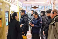 Khách hàng chờ bán đồ trang sức bằng vàng tại một máy bán vàng tự động đặt trong một trung tâm mua sắm ở Thượng Hải. (Ảnh: AFP)
