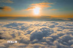 Bình minh phủ ánh vàng lên biển mây rộng lớn nhìn từ đỉnh đèo Tằng Quái. (Ảnh: Xuân Tư/TTXVN)