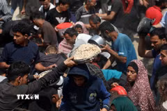 Người dân nhận thực phẩm cứu trợ tại Gaza. (Ảnh: THX/TTXVN)