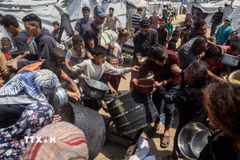 Người dân Palestine chờ được phát thực phẩm cứu trợ tại Gaza. (Ảnh: THX/TTXVN)