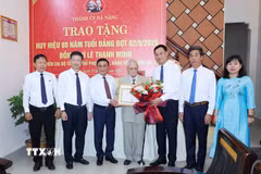 Thường trực Ban Bí thư Trần Cẩm Tú trao Huy hiệu 80 năm tuổi Đảng cho đảng viên lão thành Lê Thanh Minh, phường Hội An, thành phố Đà Nẵng. (Ảnh: Phương Hoa/TTXVN)