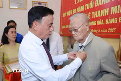 Thường trực Ban Bí thư Trần Cẩm Tú gắn Huy hiệu 80 năm tuổi Đảng cho đảng viên lão thành Lê Thanh Minh, phường Hội An, thành phố Đà Nẵng. (Ảnh: Phương Hoa/TTXVN)