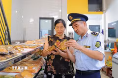 Lực lượng Quản lý thị trường kiểm tra nhãn mác trên các sản phẩm bánh Trung thu lưu thông trên thị trường. (Ảnh: Hữu Quyết/TTXVN)