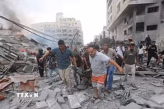 Chuyển thi thể nạn nhân sau các cuộc không kích của Israel xuống Dải Gaza. (Ảnh: IRNA/TTXVN)
