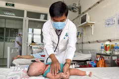 Bác sỹ khám cho bệnh nhi bị sốt xuất huyết. (Ảnh: Tuyết/TTXVN)