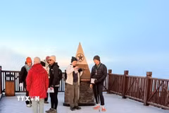 Du khách thích thú khi được trải nghiệm băng giá trên đỉnh Fansipan. (Ảnh: TTXVN phát)