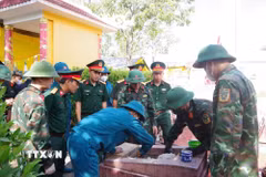 Lực lượng chuyên trách tiến hành khai quật mộ liệt sỹ. (Ảnh: Mai Trang/TTXVN)