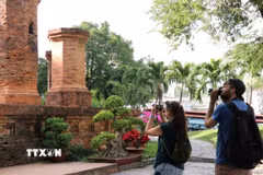 Hai du khách Nga chụp ảnh tại di tích Tháp Bà Ponagar. (Ảnh: Tiên Minh/TTXVN)