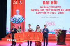Phó Thủ tướng Lê Thành Long và Bộ trưởng Bộ Văn hoá-Thể thao và Du lịch Nguyễn Văn Hùng trao cờ thi đua của Chính phủ cho các đơn vị đạt thành tích xuất sắc. (Ảnh: Hoàng Hiếu/TTXVN)