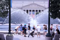 Du khách tránh nắng nóng bên đài phun nước tại khu vực National Mall (Quảng trường Quốc gia) ở thủ đô Washington D.C. (Ảnh: Ngọc Quang/TTXVN)