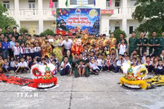 Cán bộ, chiến sỹ Đồn Biên phòng Tam Thanh chụp ảnh lưu niệm cùng các học sinh. (Ảnh: Quốc Dũng/TTXVN)