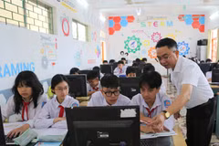 Thầy Nguyễn Chí Thanh, Giáo viên Trường THCS Nguyễn Bỉnh Khiêm, xã Vĩnh Bảo hướng dẫn học sinh làm bài tập môn Tin học. (Ảnh: Minh Thu/TTXVN)