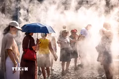 Người dân làm mát dưới hệ thống phun sương ở Budapest, Hungary. (Ảnh: THX/TTXVN phát)