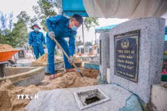 Cán bộ, chiến sỹ Ban Chỉ huy Quân sự xã Tân Biên, tỉnh Tây Ninh cẩn trọng thực hiện từng phần việc trong quá trình lấy mẫu hài cốt liệt sỹ. (Ảnh: Giang Phương/TTXVN)