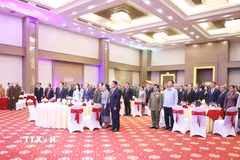 Các đại biểu tham dự Tiệc chiêu đãi thực hiện nghi lễ Chào cờ. (Ảnh: Xuân Tú/TTXVN)