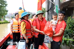 Bà Vũ Thị Quyên, Phó Chủ tịch Hội Chữ thập Đỏ tỉnh Lạng Sơn trao quà cho hộ dân có nhà bị ngập tại xã Thất Khê, tỉnh Lạng Sơn. (Ảnh: Văn Đạt/TTXVN)