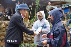 Phó Chủ tịch UBND tỉnh Quảng Ngãi Đỗ Tâm Hiển tặng quà, động viên các hộ dân bị tốc mái hoàn toàn tại xã Măng Ri. (Ảnh: Dư Toán/TTXVN)