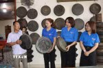 Ông Long giới thiệu những chiếc chiêng do mình sưu tầm với các đoàn viên thanh niên. (Ảnh: Đinh Hương/TTXVN)