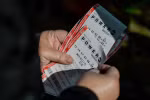 Một người cầm vé số trúng giải độc đắc 1,25 tỷ USD trong kỳ quay số Powerball tại thành phố New York, Mỹ, ngày 17/12. (Ảnh: Reuters)