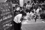 Phong trào phụ nữ “Ba đảm đang” năm 1965 nhanh chóng phát triển thành cao trào cách mạng sôi nổi, rộng lớn, huy động được sức mạnh tổng hợp của hàng chục triệu phụ nữ từ nông thôn tới thành thị, từ miền ngược đến miền xuôi, trên mọi lĩnh vực hoạt động. Trong ảnh: Học sinh trường cấp III Yên Hòa, Hà Nội đăng ký phong trào “Ba đảm nhiệm,' sau này là phong trào phụ nữ “Ba đảm đang”. (Ảnh: Thanh Tụng/TTXVN)