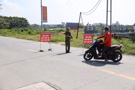 Lực lượng chức năng tại Sóc Sơn lập rào chắn và hướng dẫn người và phương tiện chuyển sang lộ trình khác nhằm đảm bảo an toàn. (Ảnh: Vũ Quang/TTXVN)