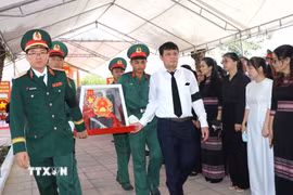 Thiếu tướng Lương Đình Chung, Bí thư Đảng uỷ Chính uỷ Quân khu và đồng chí Nguyễn Đức Tuy, Phó Bí thư Tỉnh uỷ, Chủ tịch HĐND tỉnh Quảng Ngãi, đưa liệt sĩ về nơi an nghỉ. (Ảnh: Đinh Hương/TTXVN)
