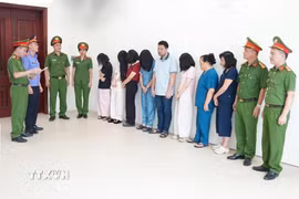 Cơ quan công an đọc lệnh khởi tố vụ án, khởi tố bị can nhóm đối tượng liên quan đến Phòng khám Đa khoa Y học Nghệ An về tội "Lừa dối khách hàng". (Ảnh: TTXVN phát)