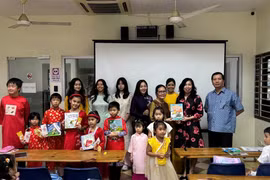 Thứ trưởng Bộ Ngoại giao Lê Thị Thu Hằng tặng sách cho giáo viên và học sinh lớp tiếng Việt tại Malaysia. (Ảnh: TTXVN phát)