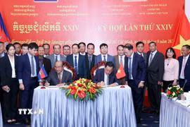 Thượng tướng Võ Minh Lương (phải), Thứ trưởng Bộ Quốc phòng, Chủ tịch Ủy ban Chuyên trách Chính phủ nước CHXHCN Việt Nam và Đại tướng Pol Saroeun (trái), Cố vấn cấp cao của Quốc vương Campuchia, Chủ tịch Ủy ban Chuyên trách Chính phủ Campuchia ký biên bản Kỳ họp. (Ảnh: Xuân Khu/TTXVN)