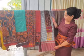 Chị Neáng Chanh Ty, Chủ nhiệm Hợp tác xã dệt thổ cẩm Khmer Văn Giáo (xã An Cư, tỉnh An Giang) giới thiệu những sản phẩm độc đáo của làng nghề. (Ảnh: Công Mạo/TTXVN)
