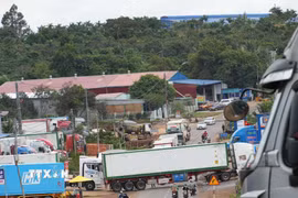 Xe container di chuyển vào bãi tập kết và chắn ngang đường trên quốc lộ 26. (Ảnh: Tuấn Anh/TTXVN)