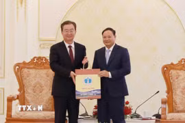 Bí thư Tỉnh ủy Lai Châu Lê Minh Ngân (bên phải) tặng sản phẩm Hồng trà của tỉnh Lai Châu cho Bí thư Tỉnh ủy Vân Nam Trung Quốc Vương Ninh. (Ảnh: Quý Trung/TTXVN)