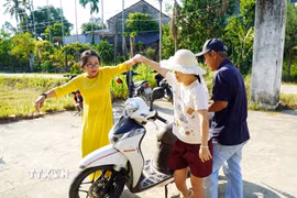 Thầy cô, người thân dìu các em khuyết tật vào dự lễ khai giảng. (Ảnh: Lê Phước Ngọc/TTXVN)