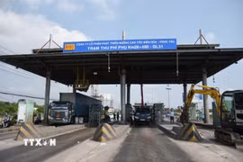 Máy móc, nhân lực thực hiện tháo dỡ các kết cấu tại trạm thu phí T2 trên Quốc lộ 51, đoạn qua Đồng Nai. (Ảnh: Công Phong/TTXVN)
