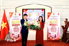 Tổng Lãnh sự Việt Nam tại Osaka Nguyễn Trường Sơn tặng hoa chúc mừng thành công của Đại hội. (Ảnh: Bùi Hà/TTXVN)