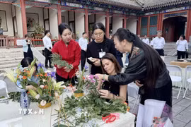 Các phóng viên, nhà báo nước ngoài tại Bắc Kinh tìm hiểu văn hóa cắm hoa của Trung Quốc. (Ảnh: Công Tuyên/TTXVN)