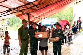 Các lực lượng chức năng thăm hỏi, động viên gia đình nạn nhân. (Ảnh: TTXVN phát)