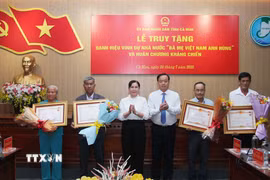 Ông Huỳnh Quốc Việt, Phó Bí thư thường trực Tỉnh ủy và bà Lê Thị Nhung, Phó Chủ tịch Thường trực Hội đồng Nhân dân tỉnh Cà Mau trân trọng trao tặng Danh hiệu vinh dự Nhà nước "Bà mẹ Việt Nam Anh hùng" cho thân nhân 4 Bà mẹ Việt Nam Anh hùng được Chủ tịch nước truy tặng. (Ảnh: Chanh Đa/TTXVN)