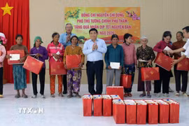 Phó Thủ tướng Chính phủ Nguyễn Chí Dũng tặng quà Tết cho đồng bào Raglai tại xã Anh Dũng. (Ảnh: Công Thử/TTXVN)