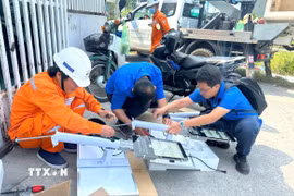 Các kỹ sư trẻ thử nghiệm mô hình lưới điện. (Ảnh: TTXVN phát)