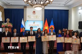 Phó Bí thư Đảng uỷ Việt Nam tại Liên bang Nga Ngô Thị Thu Hoài trao bằng khen cho cá nhân đạt thành tích xuất sắc. (Ảnh: Tâm Hằng/TTXVN)