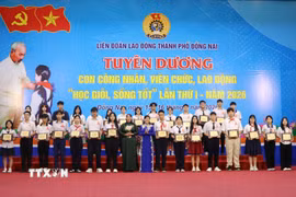 Lãnh đạo Liên đoàn Lao động thành phố Đồng Nai trao thưởng cho con công nhân học giỏi, sống tốt. (Ảnh: Lê Xuân/TTXVN)