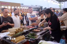 Du khách quốc tế chọn mua thưởng thức ẩm thực tại Lễ hội Đà Nẵng Food Tour 2025. (Ảnh: Trần Lê Lâm/TTXVN)