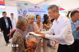 Đại sứ Nguyễn Minh Vũ cùng đoàn trao quà cho người dân Campuchia. (Ảnh: Minh Hưng/TTXVN)