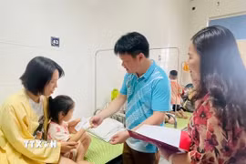 Lãnh đạo thành phố Cao Bằng thăm hỏi các em nghi bị ngộ độc thực phẩm được điều trị tại Bệnh viện đa khoa tỉnh. (Ảnh: TTXVN phát)