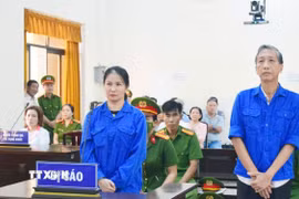 Bị cáo Lê Văn Mót (phải) lĩnh án 18 năm tù về tội “Lừa đảo chiếm đoạt tài sản.” (Ảnh: Văn Sĩ/TTXVN)