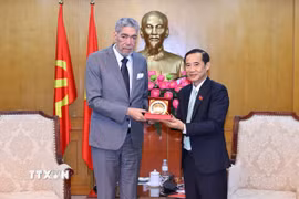 Đồng chí Phó Bí thư chuyên trách Đảng uỷ Dân vận, Mặt trận và các đoàn thể Trung ương Nguyễn Thái Học trao tặng biểu trưng cho đồng chí Miguel Mejia, Tổng Bí thư Đảng Phong trào Cánh tả Thống nhất (MIU), Cộng hòa Dominica. (Ảnh: Minh Đức/TTXVN)