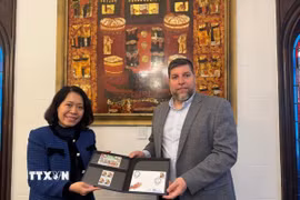 Nghị sỹ Victor Aldaya trao Đại sứ Ngô Minh Nguyệt bộ tem do Bưu chính Uruguay tháng 12/2013, nhân kỷ niệm 20 năm quan hệ ngoại giao Việt Nam-Uruguay, với chân dung của Đại tướng Võ Nguyên Giáp. (Ảnh: Diệu Hương/TTXVN) 