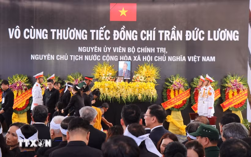 Nghi lễ thả hoa vào huyệt. (Ảnh: Phạm Cường/TTXVN)