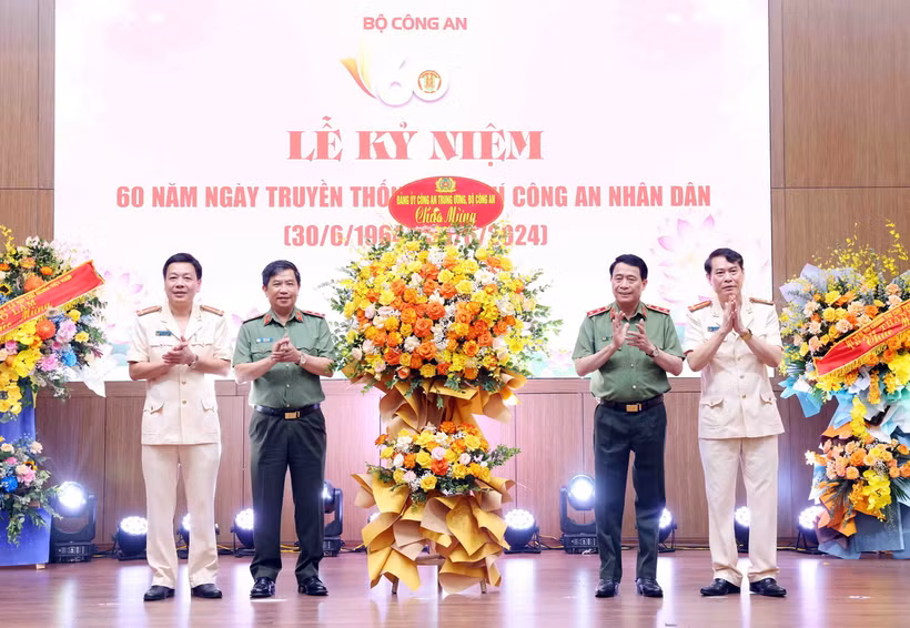 Trung tướng Lê Quốc Hùng, Ủy viên Trung ương Đảng, Thứ trưởng Bộ Công an, tặng hoa chúc mừng Tạp chí Công an Nhân dân. (Ảnh: Phạm Kiên/TTXVN)